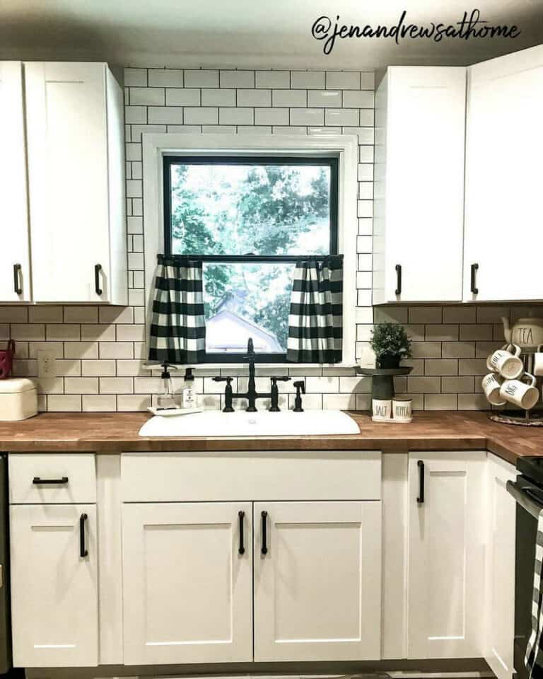 white subway tile backsplash with black grout feature