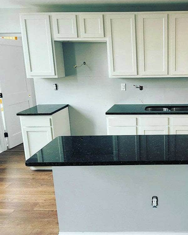 verde butterfly granite with white cabinets feature