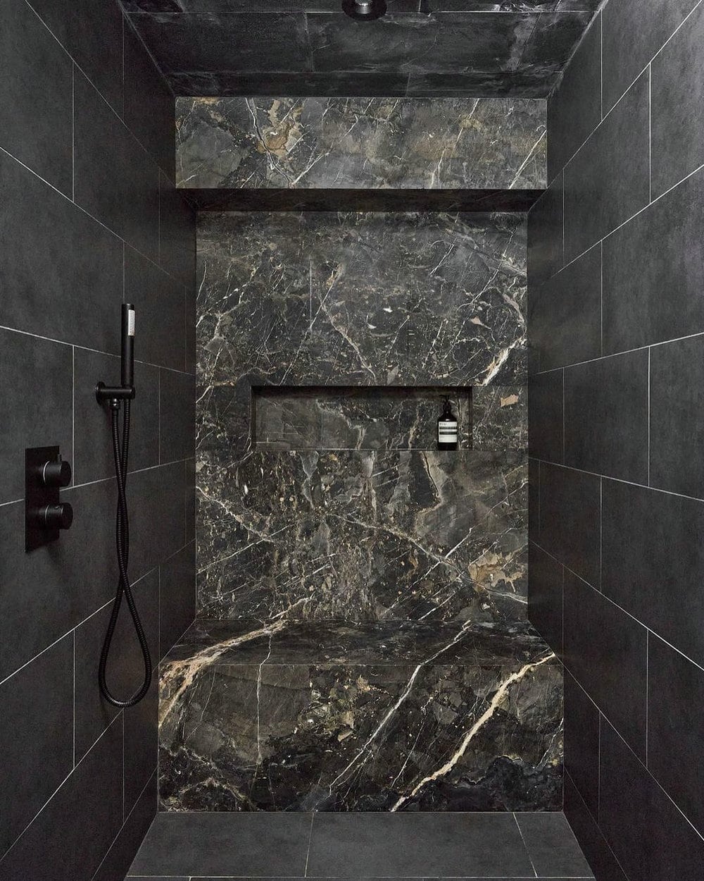 bathroom with black tiles on the wall