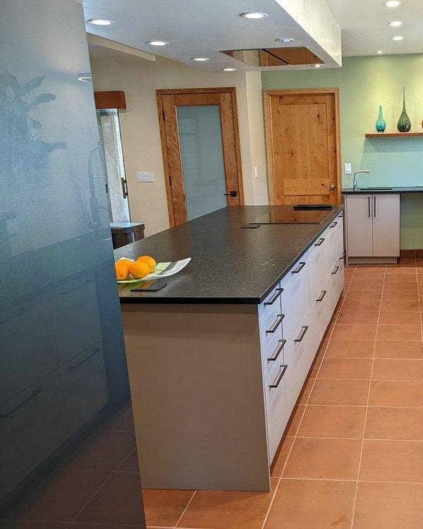 taupe kitchen cabinets with black countertops feature