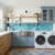 Laundry room featuring Lustra blue glass tile backsplash over white countertop