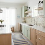 Bright kitchen with peel and stick tile backsplash, light green cabinets, and natural light. Perfect for easy home updates an.