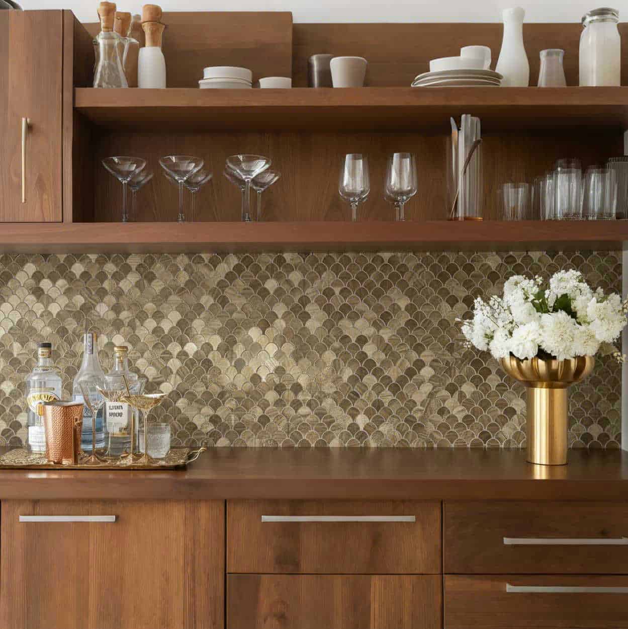 Modern kitchen with peel and stick tile backsplash, wooden cabinets, and glassware display.