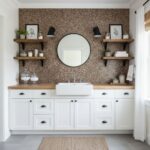 Bathroom wall with peel and stick wall tile backsplash, round mirror, and wooden shelves.