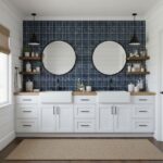 Mirror and shelf bathroom decor with glass mosaic tile backsplash.