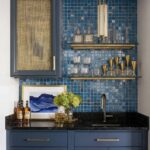Blue glass tile backsplash with decorative glassware and gold accents.
