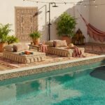 Relaxing outdoor pool area featuring elegant glass mosaic tiles and comfortable lounge cushions. Perfect for outdoor relaxati.
