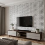 Black and white mosaic tile wall with textured surface behind TV.