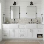 Two mirrors above a white double vanity with shell tile backsplash.