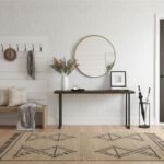 A stylish interior featuring a wall with mother of pearl shell tiles, complemented by a round mirror, console table, and deco.