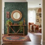 Green peel and stick tile wall with decorative mirror and plants in stylish living space.