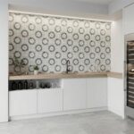 Decorative tile wall featuring a floral pattern in shades of gray and white.