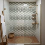 Patterned wall tiles in a bathroom shower with a white and dark gray geometric design.