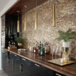 Decorative shell tile wall with mother of pearl accents and gold pendant lighting.