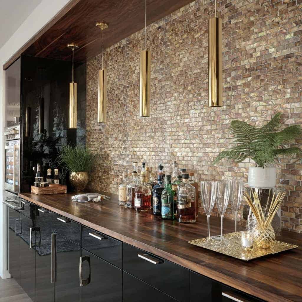 Decorative shell tile wall with mother of pearl accents and gold pendant lighting.