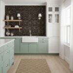 A modern kitchen featuring a peel and stick tile backsplash with a dark, textured design, complemented by light green cabinet.