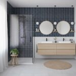 Glass tile backsplash in modern bathroom with double mirrors and shower enclosure.
