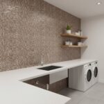 A modern laundry room featuring a wall covered with mother of pearl shell tiles, adding a luxurious and natural touch to the.