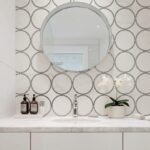 White wall tiles with black circular patterns, smooth texture, modern design.