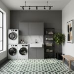 Bright laundry room with green and white geometric patterned tiles, gray cabinetry, black shelving, and a potted plant for a.