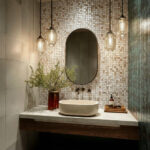 Elegant bathroom vanity with shell tile backsplash, oval mirror, and modern lighting fixtures.