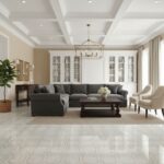A spacious living room featuring a gray upholstered sofa, white built-in cabinets, and a stylish chandelier, creating a sophi.