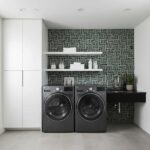 Black and white geometric patterned tile on laundry room wall, with modern appliances and shelving.