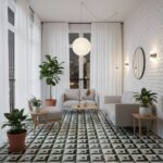 Bright living room with white brick walls, featuring a cozy sofa, potted plants, and a patterned tile floor. Large windows wi.
