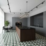 Bright, contemporary kitchen featuring gray cabinetry, black marble island, and geometric patterned floor tiles in green and.
