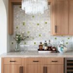 Elegant kitchen backsplash featuring mother of pearl shell tiles with green accents.