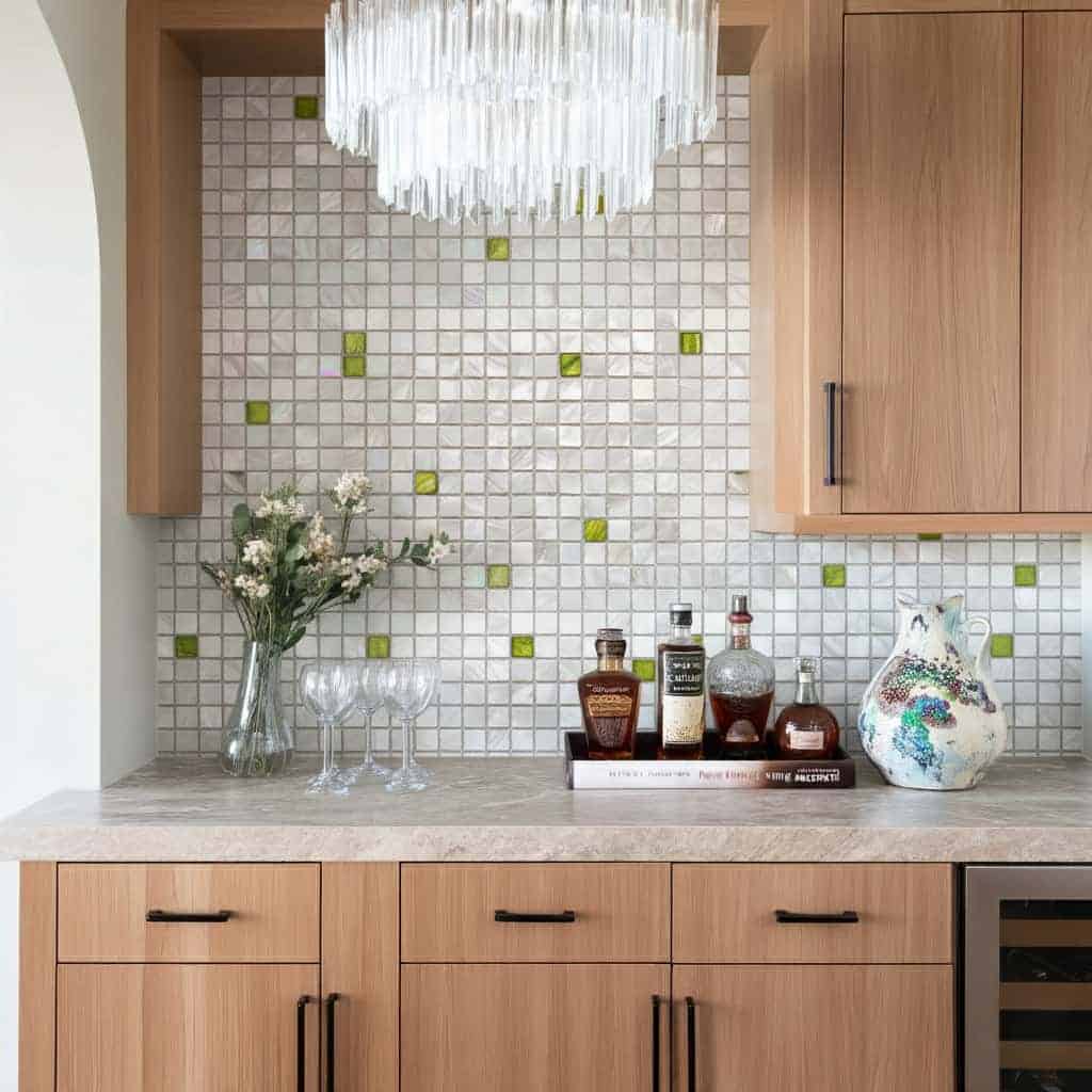 Elegant kitchen backsplash featuring mother of pearl shell tiles with green accents.