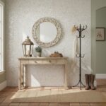 Elegant entryway with shell tile wall, wooden console table, mirror, lantern, and coat rack.