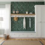 Green peel and stick wall tile with hooks and decor in a modern entryway.
