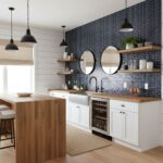 Modern kitchen with navy glass mosaic tile backsplash and white cabinetry.