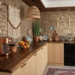 A stylish kitchen featuring a shell tile backsplash with mother of pearl accents, complemented by decorative plates and natur.