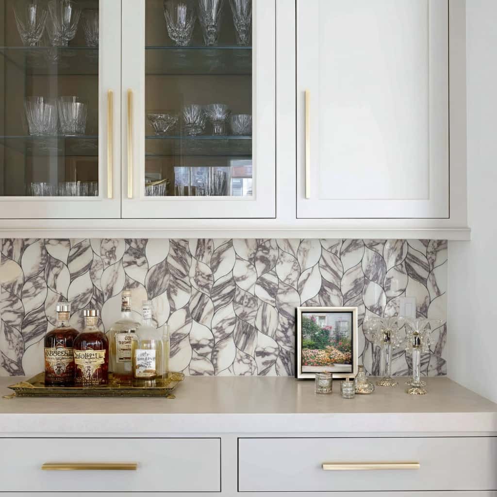 Modern kitchen with peel and stick wall tile backsplash and white cabinetry.