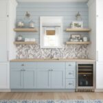 Image of a modern kitchen with peel and stick tile backsplash and light blue cabinetry.