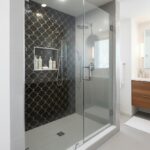 Black scalloped tile with gold accents, textured surface, modern style.