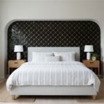Black scallop tile with gold accents behind the bed, textured and glossy finish.