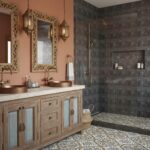 Elegant bathroom with copper sinks, intricate mirrors, and a textured tile shower. Warm tones and detailed design create a lu.