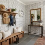 Bright entryway featuring black and white patterned wall tiles, wooden bench, and decorative accessories.
