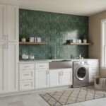 Green peel and stick wall tile backsplash behind laundry sink and washer.
