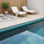 Relaxing poolside area featuring sleek glass tile backsplash and comfortable lounge chairs. Perfect for outdoor leisure and s.