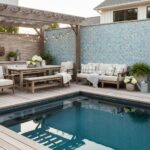 Outdoor pool with glass tile backsplash and stylish patio furniture for relaxing.