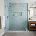 A modern bathroom featuring a glass tile backsplash in a walk-in shower with a built-in niche.