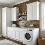 Bright laundry room with peel and stick tile backsplash behind the sink and washer. Modern white cabinets and open shelves cr.