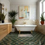 Elegant white bathtub with gold clawfoot legs in a modern bathroom setting.