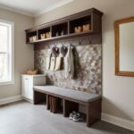 Modern entryway with peel and stick tile backsplash, bench, and storage hooks in a neutral-toned home.