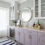 Bright kitchen with peel and stick wall tile backsplash, white cabinetry, and gold accents.
