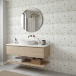 Bathroom with mother of pearl shell tiles creating a shimmering, luxurious wall feature behind a modern vanity and round mirr.